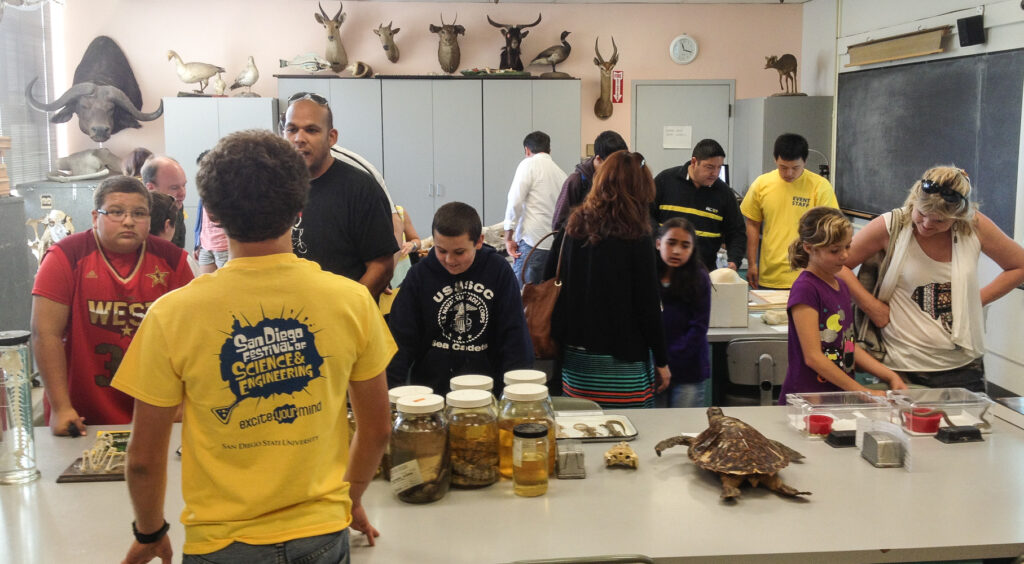 members of the public looking a museum specimens in a classroom